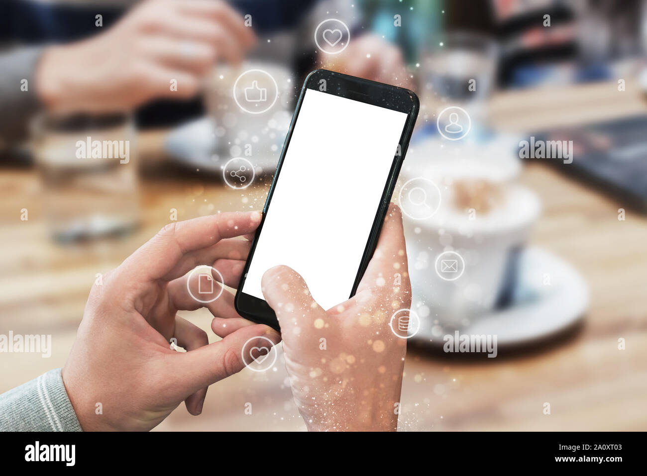 Phone in man hands with isolated display for mockup. Internet of things icons beside. Concept of using mobile technologies. Stock Photo
