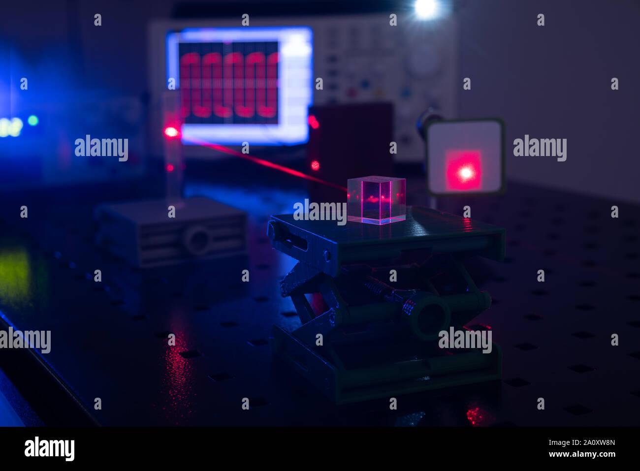 Experiment in optic lab with laser device. Red laser on optical table