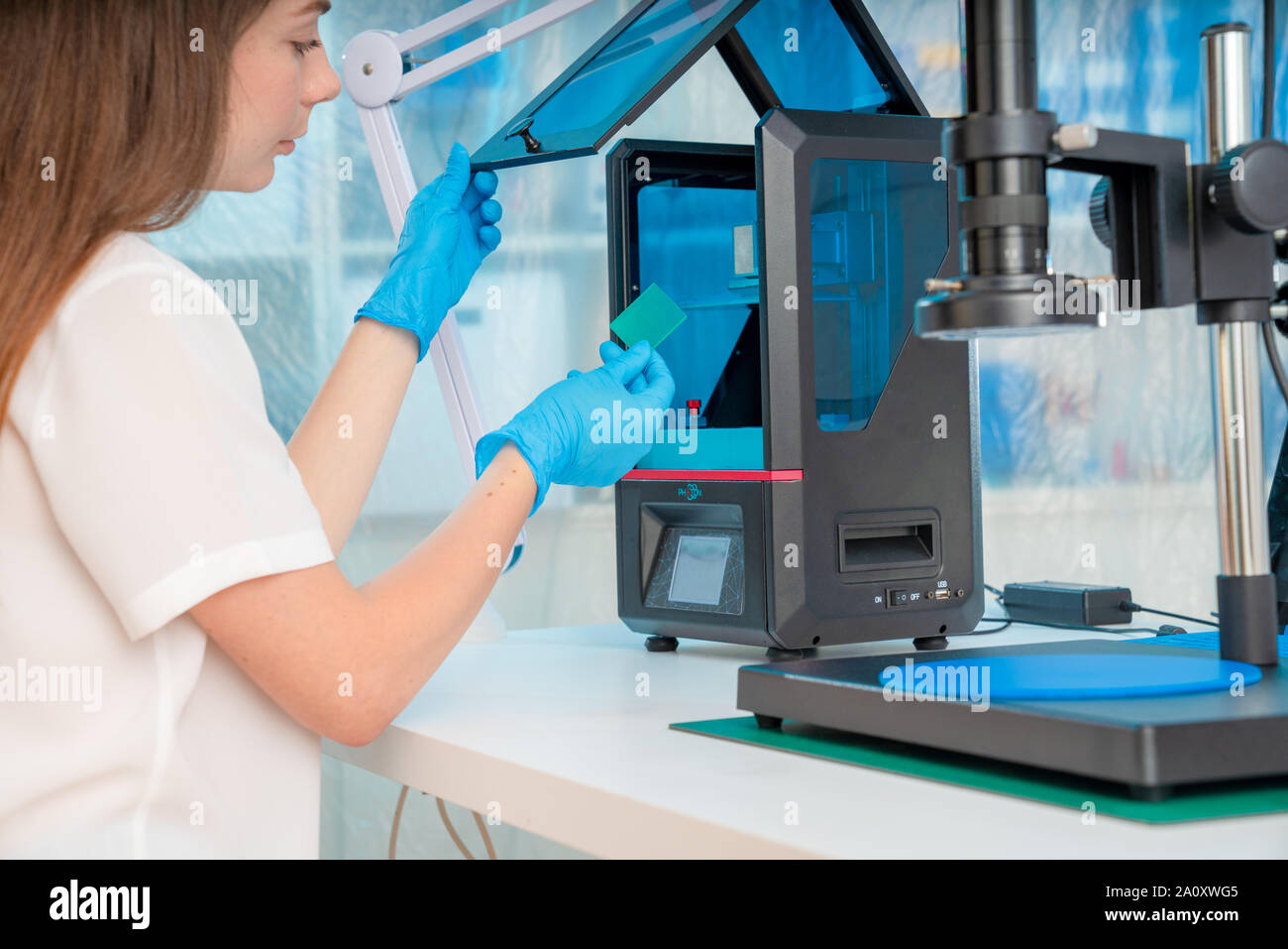 Woman worker in control of Resin LCD / DLP / SLA 3D Printer in technology lab Stock Photo