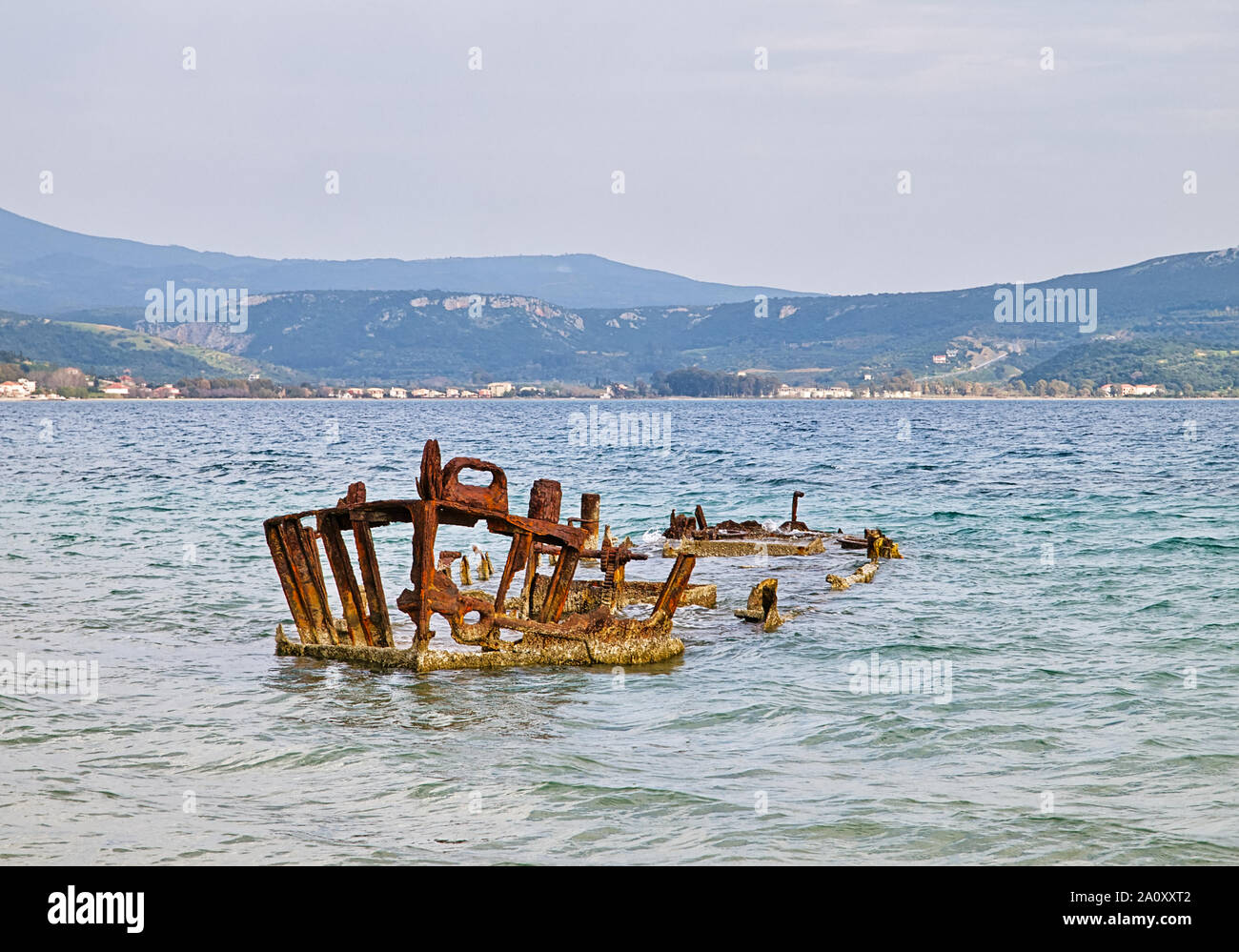 Rusty ship wreck in wavy sea water, Gialova lagoon, Peloponnese Greece. Stock Photo
