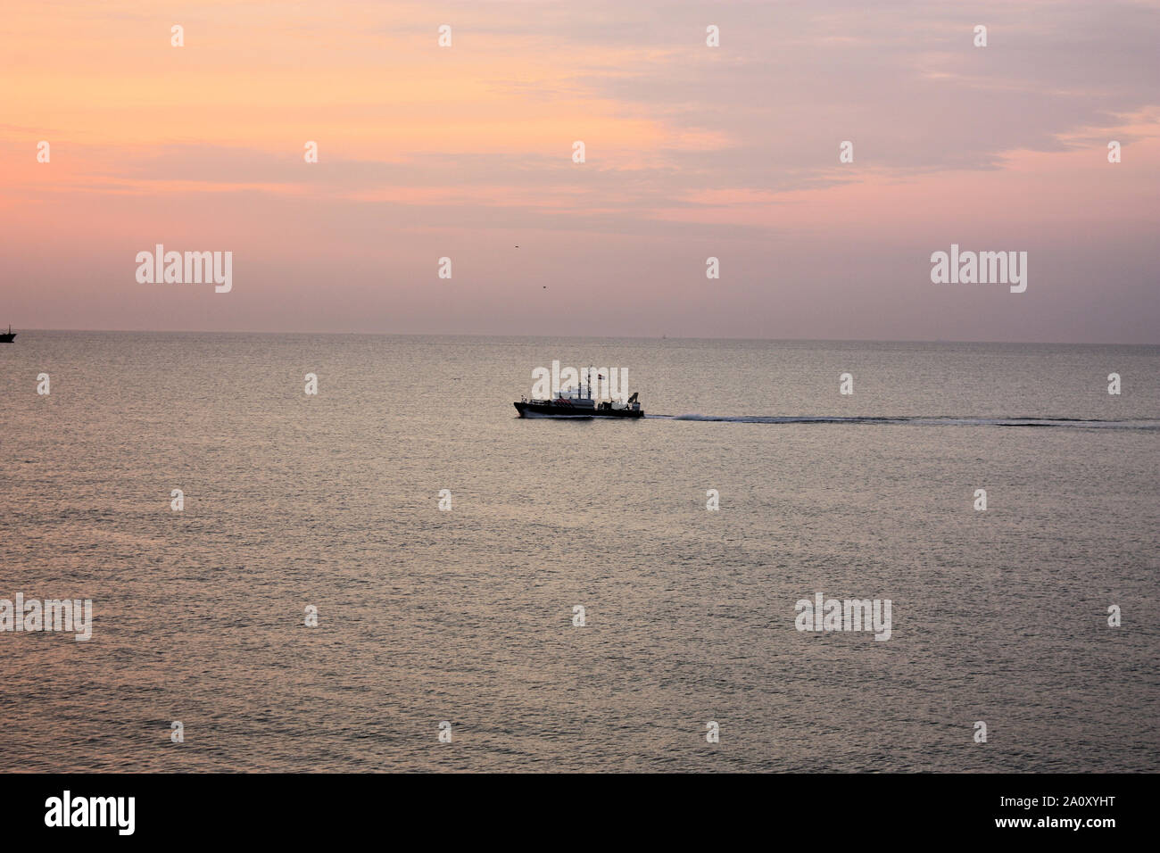 A beautiful view at the waters of Scheveningen in a summer evening when a passenger boat is passing through the sea. Stock Photo
