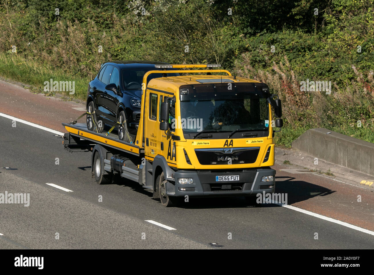 A AA vehicle breakdown recovery truck traveling northbound on the M6 motorway near Garstang in Lancashire, UK Stock Photo