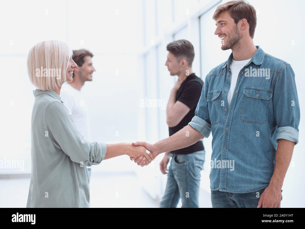 coworkers shaking hands in the office lobby. Stock Photo