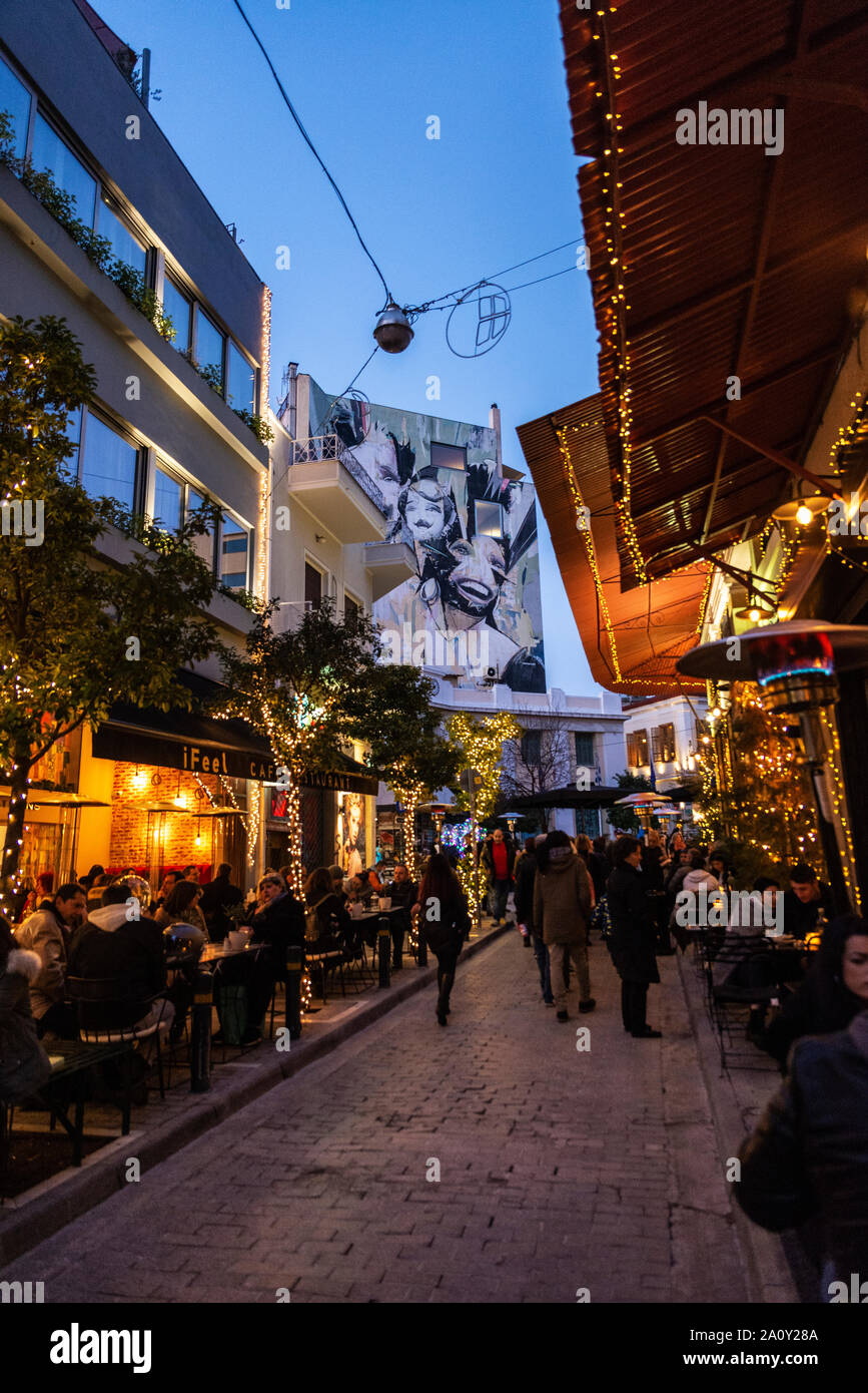 Athens, Greece - January 2, 2019: Street decorated with christmas lights at night with people on the terraces of the bars in Athens, Greece Stock Photo