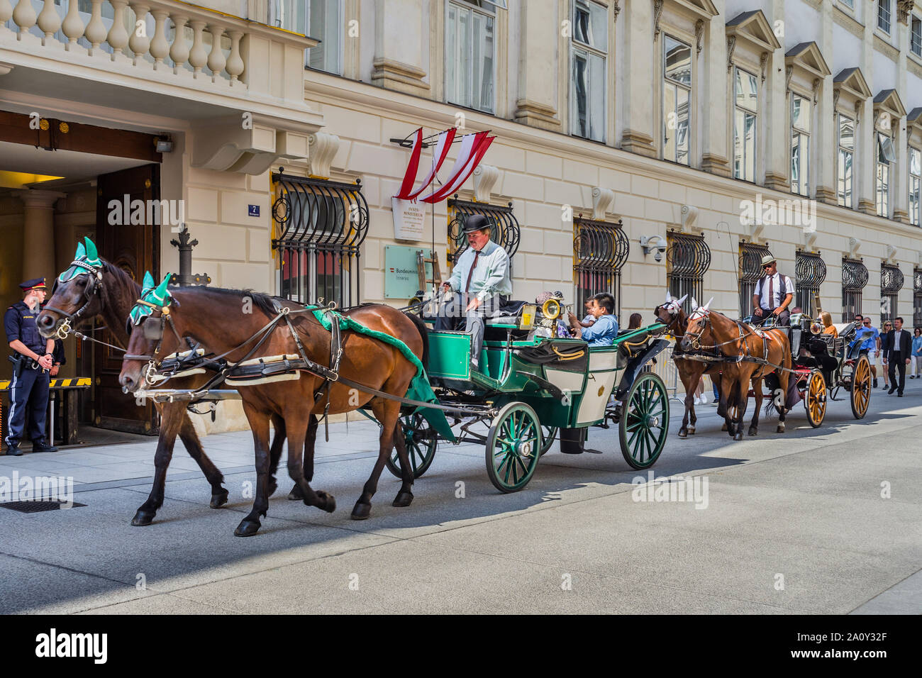 Horse-drawn carriages (fiakers) carrying tourists along the Herrengasse, Vienna, Austria. Stock Photo