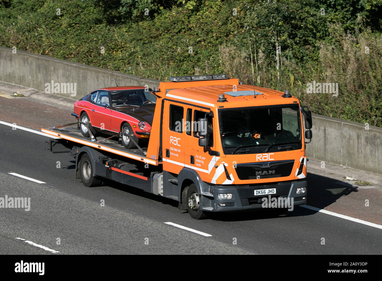A MAN RAC flatbed vehicle breakdown recovery truck traveling northbound on the M6 motorway near Garstang in Lancashire, UK Stock Photo