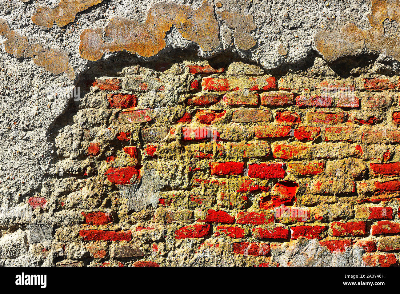 cracked plaster on brick wall, texture on facade of abandoned building Stock Photo