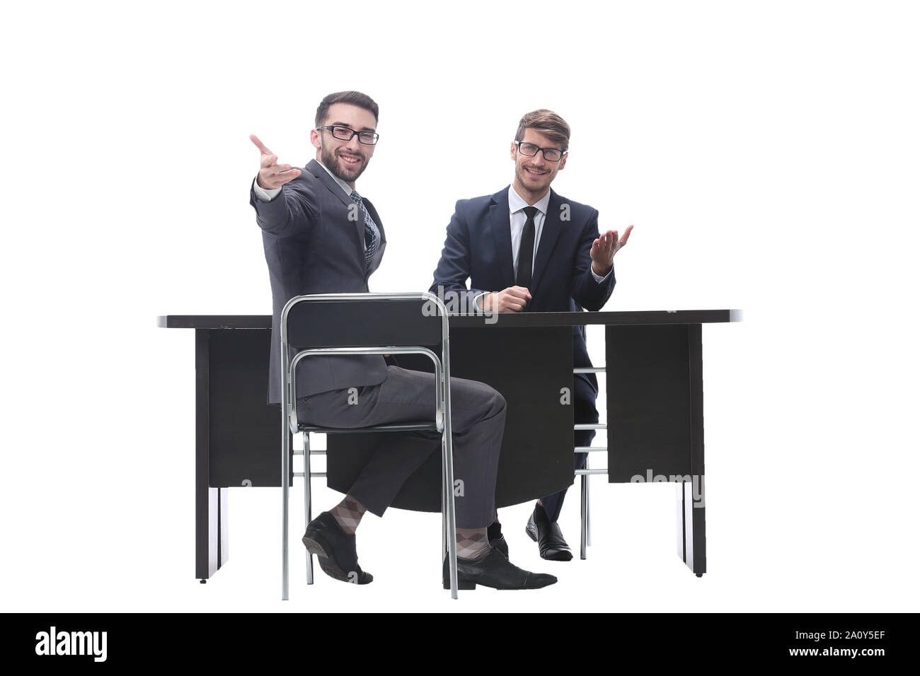 two businessmen talking, sitting at his Desk Stock Photo Alamy