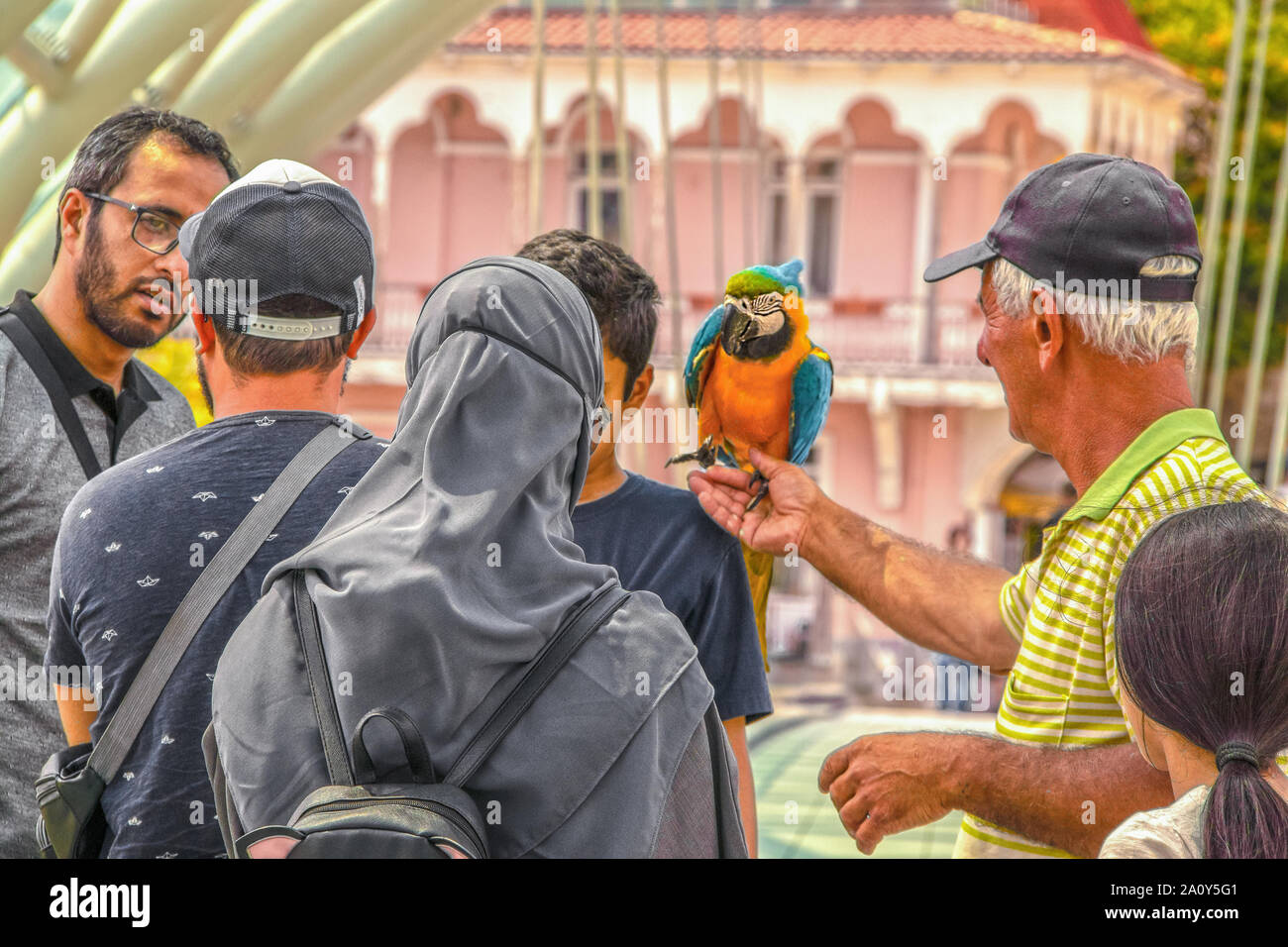 7 19 2019 Tbilisi Georgia -Pedestrian Bridge of Peace - woman in hijab with cute backpack with ears and sunglasses - husband conversed earnestly with Stock Photo