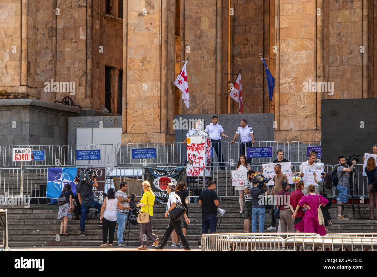 7-16 2019 Tbilisi Georgia - Political protests outside Parliament building in Tbilisi Georgia with guards watching and reporters interviewing and sign Stock Photo