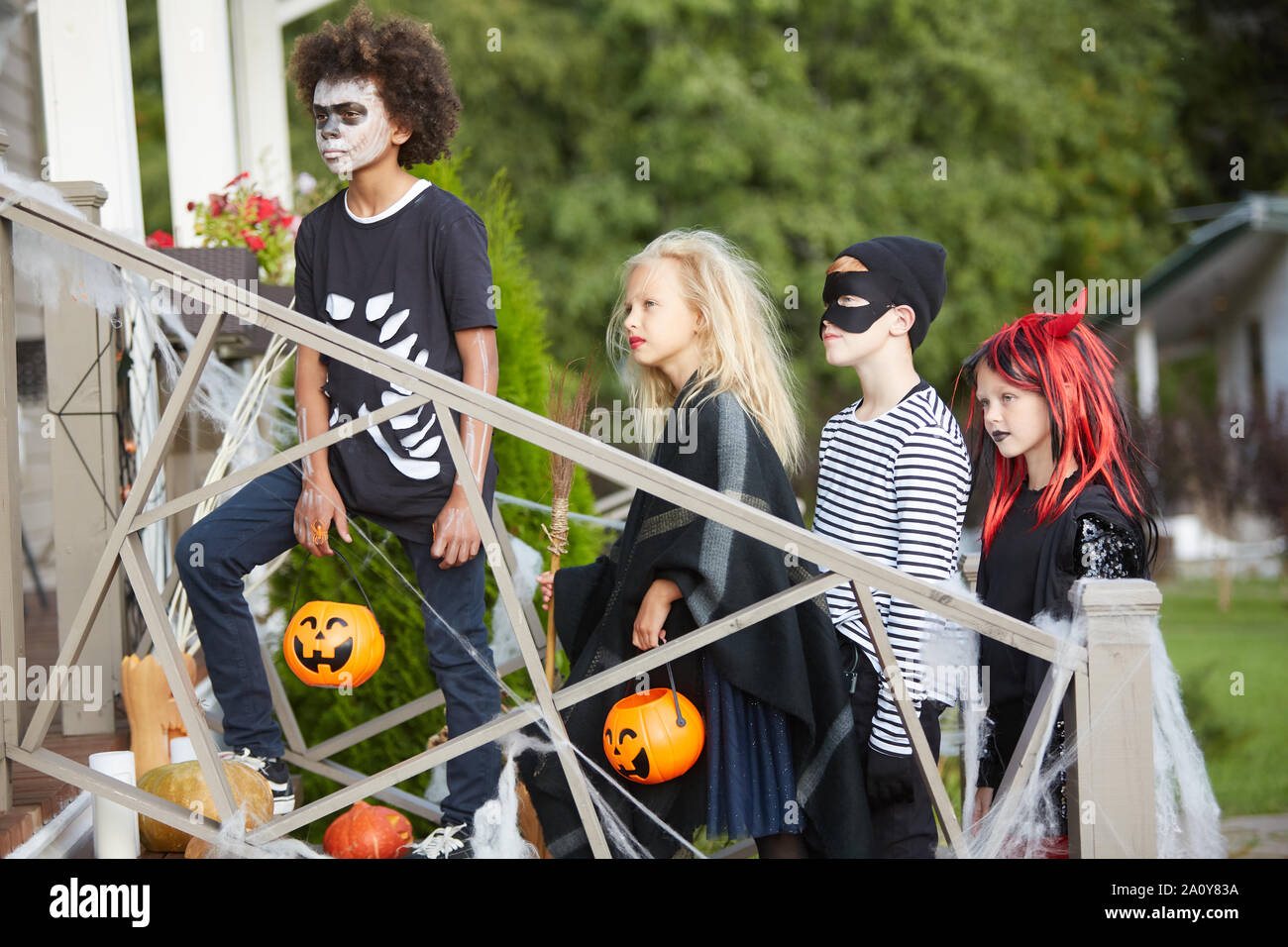 Multiethnic group of children trick or treating together walking to