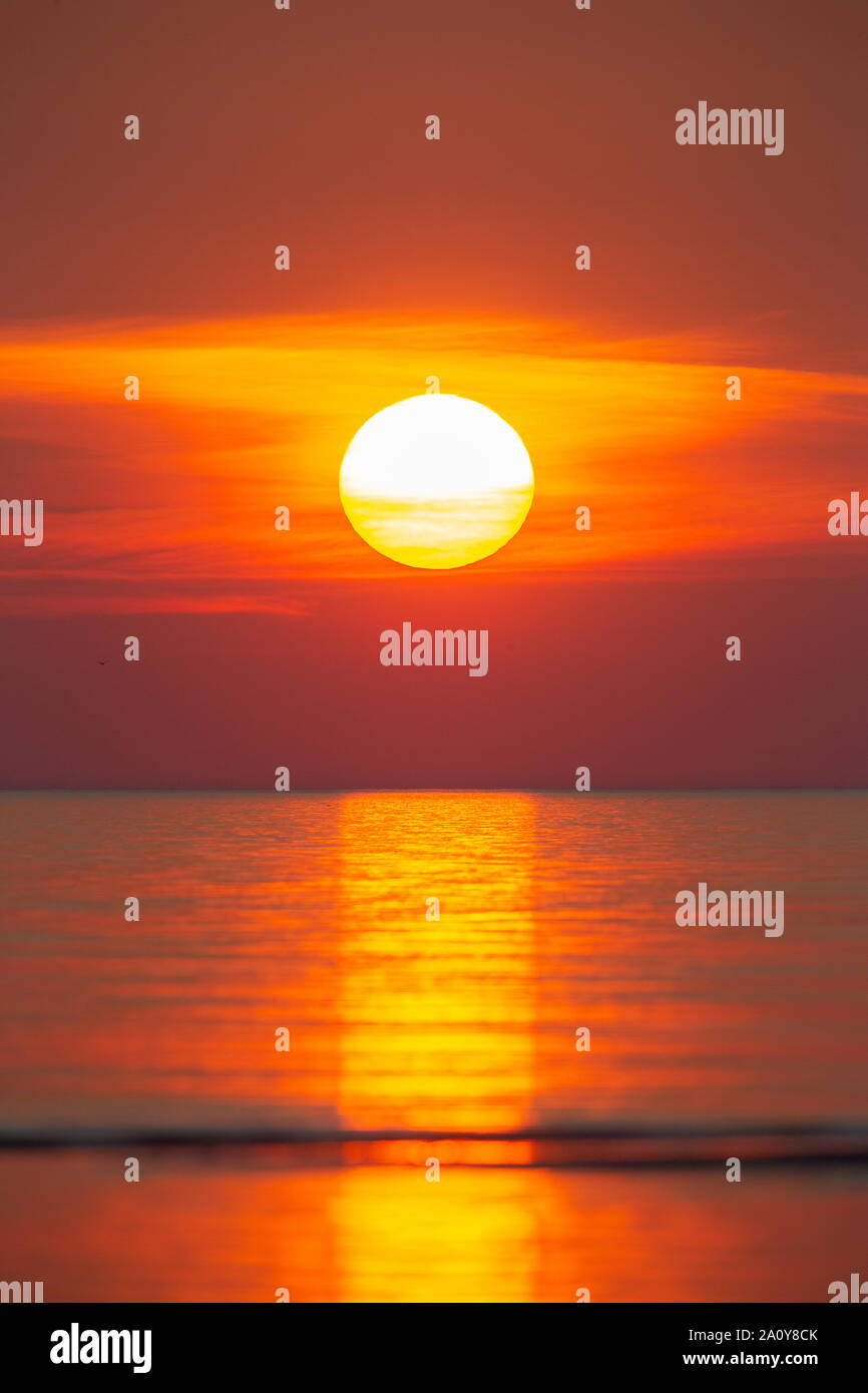 Sun setting into sea Stock Photo