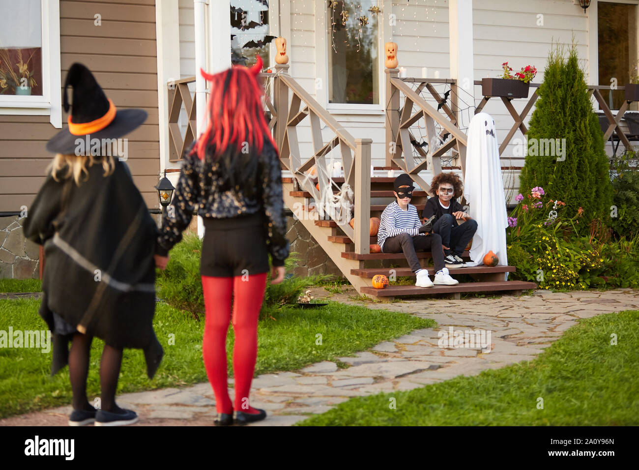 Multi-ethnic group of kids meeting outdoors on Halloween to go trick or treating together, copy space Stock Photo