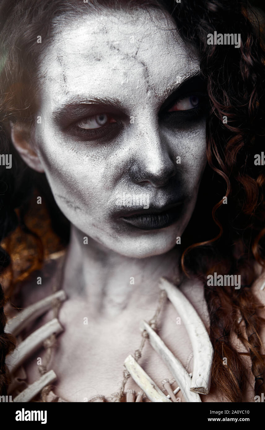 Halloween theme: scary sullen voodoo witch. Close-up portrait of the evil hag. Zombie woman (undead) Stock Photo