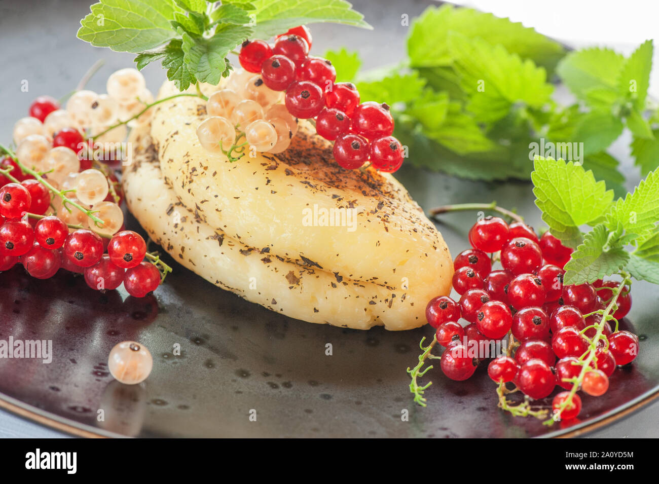 Grilled halloumi cheese with red currants and mint leaves. Unconventional serving of halloumi cheese. Farm natural product. Close-up. Stock Photo