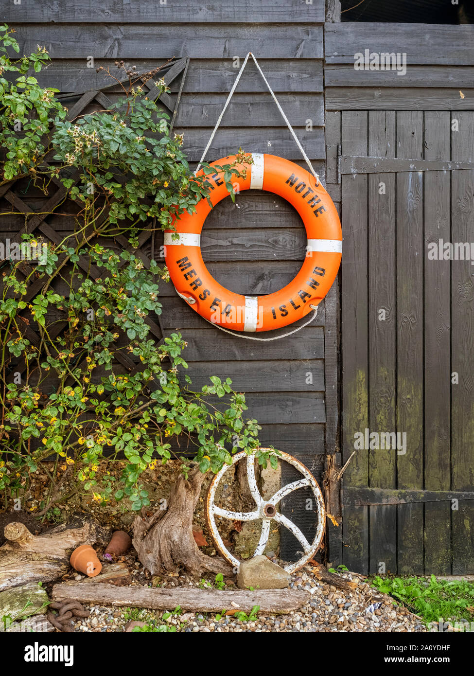 WEST MERSEA, ESSEX,UK - AUGUST 31, 2018:  Orange Life buoy on old shed Stock Photo