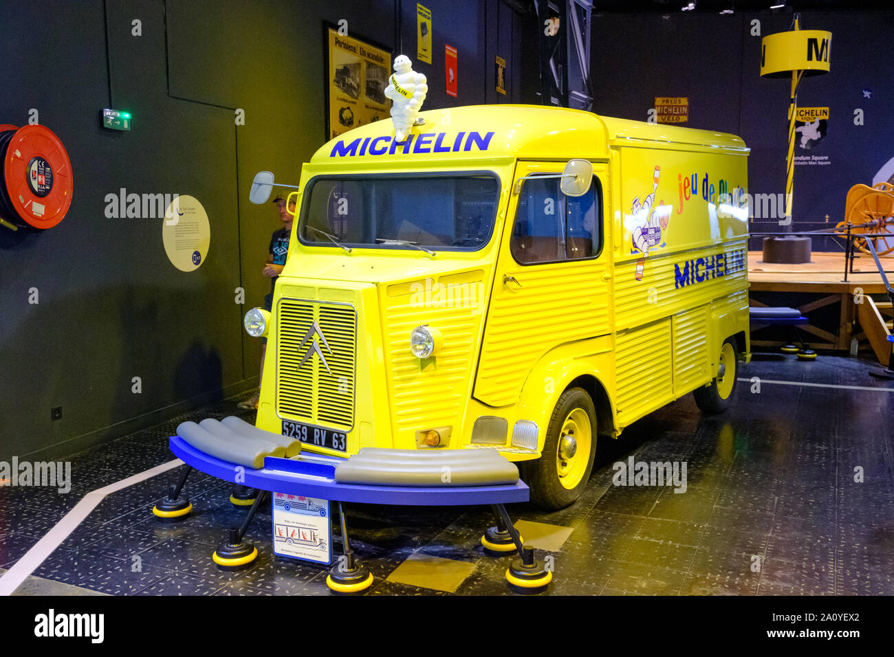 Yellow Citroen van with Michelin Tyre Man (Bibendum) on roof in the L'Aventure Michelin museum in Clermont Ferrand, France Stock Photo
