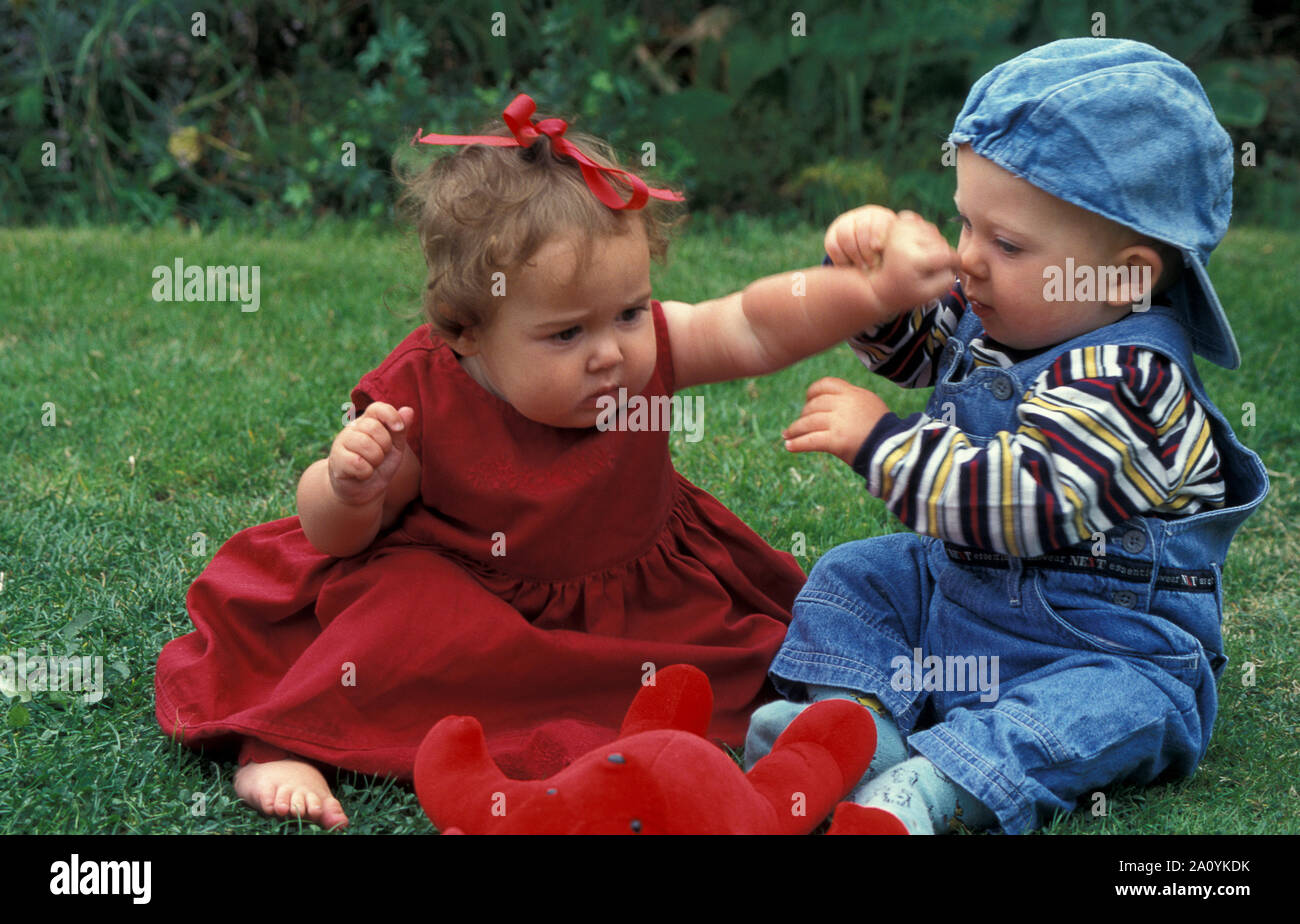Baby girl punching baby boy Stock Photo