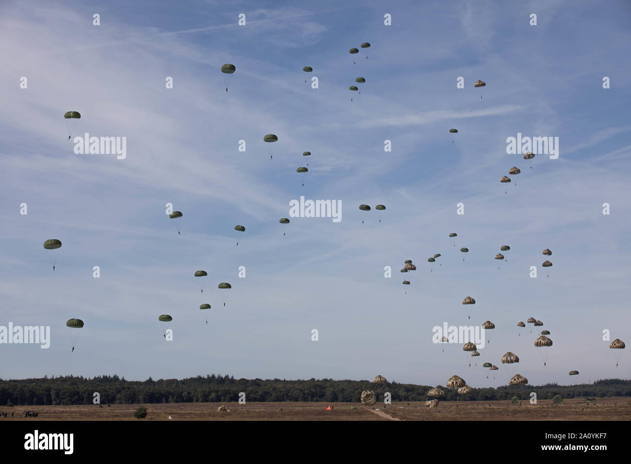 A group of U.S. Army and International Paratroopers parachute out of C-130 Aircraft onto Ginkelse Heide Drop Zone (Y) during the 75th Anniversary of Market Garden at Arnhem, Netherlands., September 20, 2019. These current Paratroopers are honoring the memories of the Paratroopers from all Allied Nations that participated in the jump in September 1944, as part of Operation Market Garden, the largest Airborne operation in the history of Warfare. (U.S. Army Reserve Photo by Staff Sgt. Austin Berner) Stock Photo