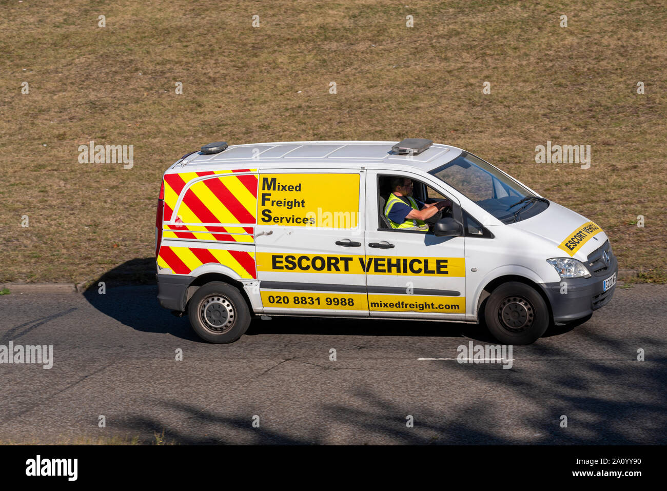 Mixed Freight Services escort vehicle van driving on the road near Heathrow, London, UK. Transport and logistics company Stock Photo