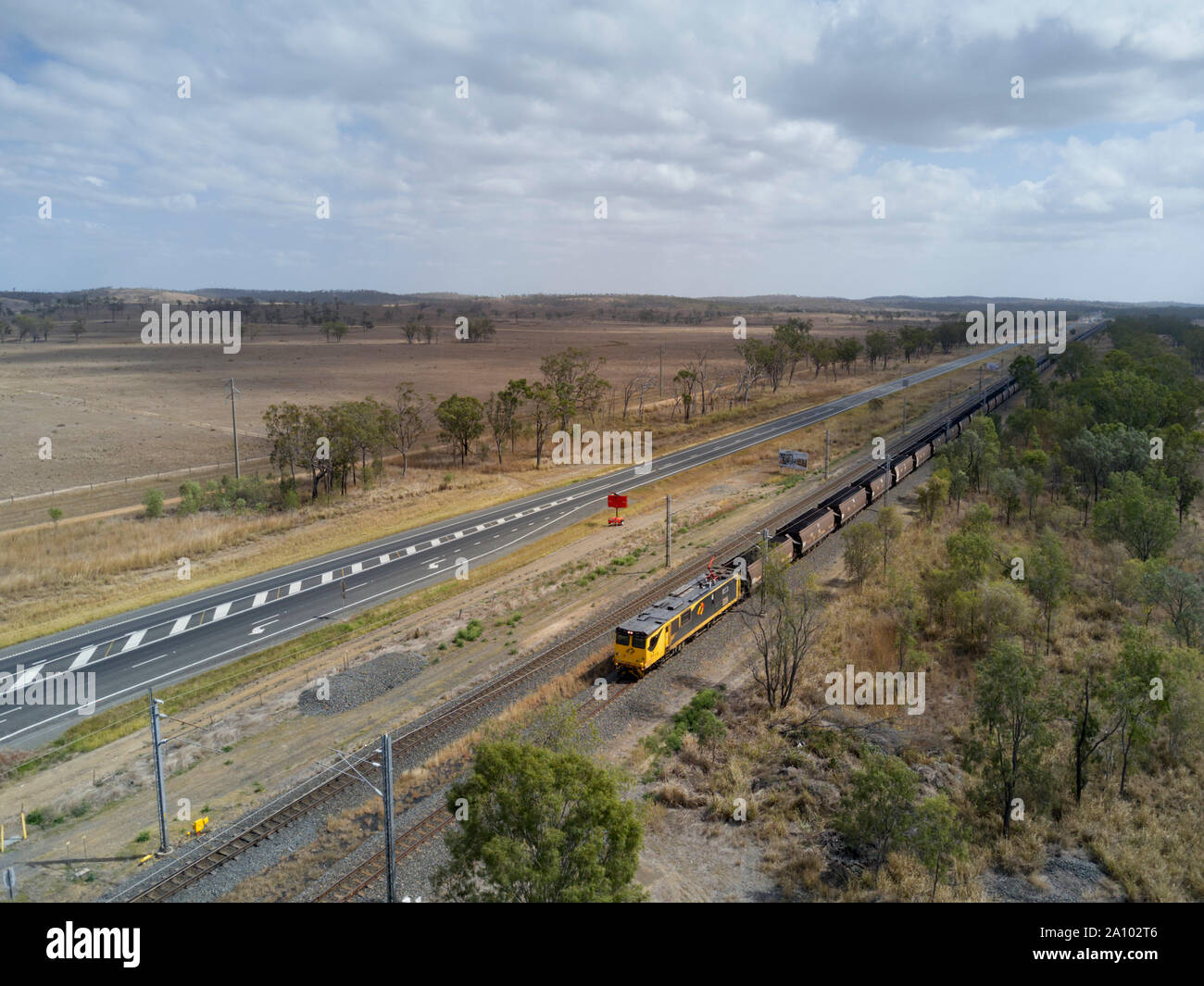 Aerial of Coal Train travelling along side the Bruce Highway to