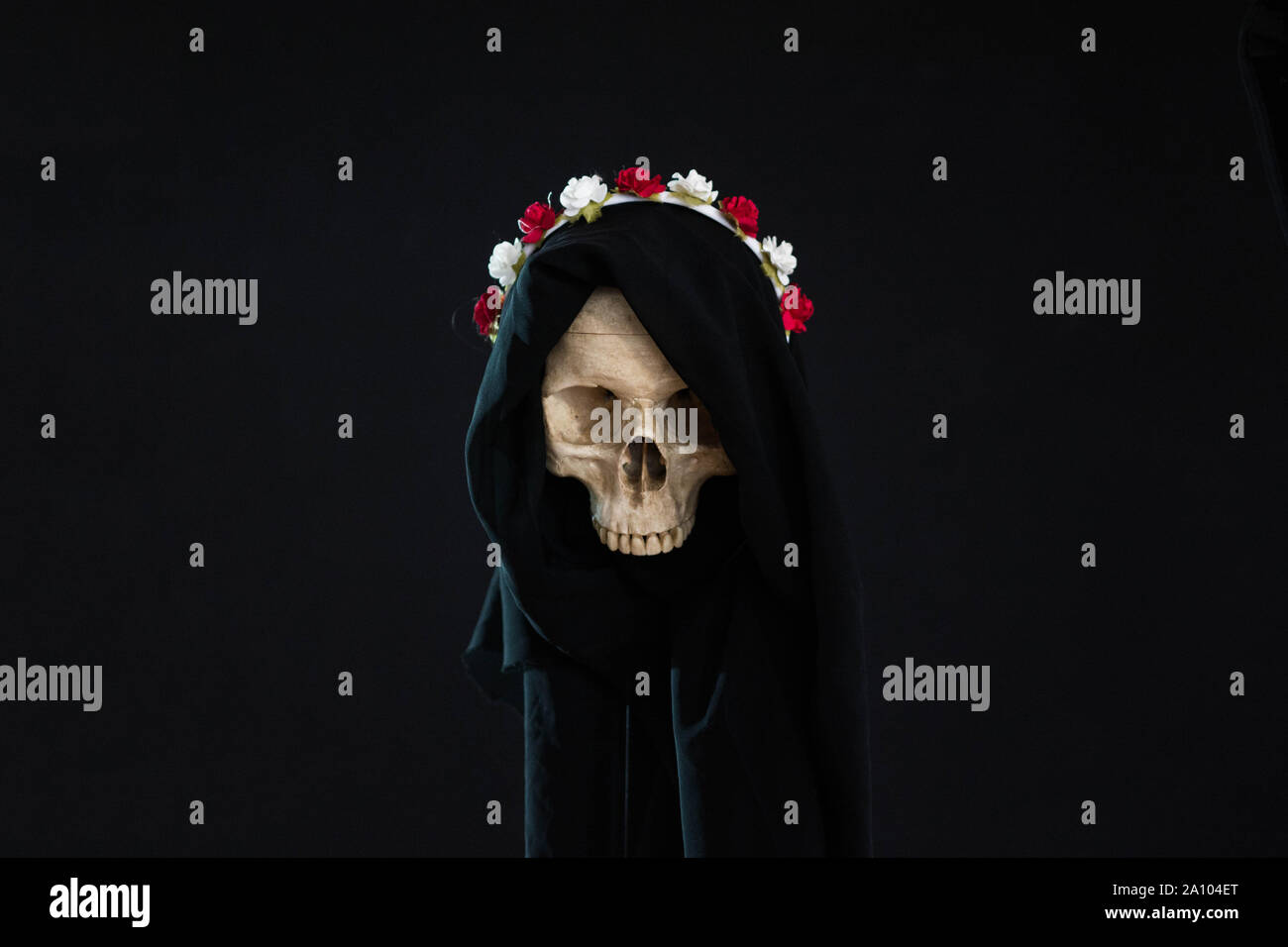 Death wearing a black robe and a crown of flowers Stock Photo