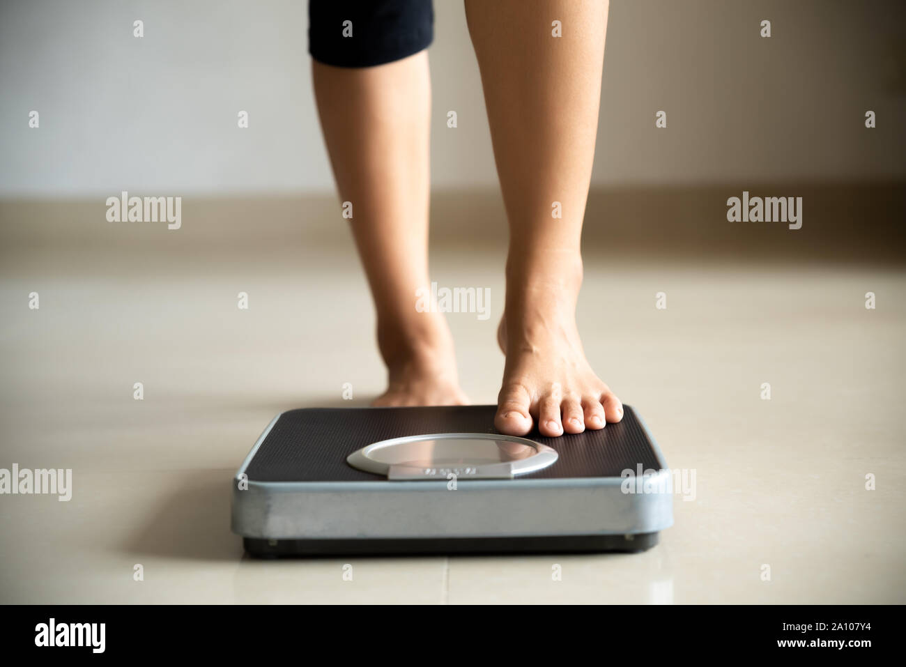 Female leg stepping on weigh scales. Healthy lifestyle, food and sport