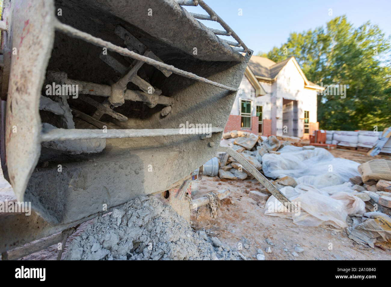 Close-up of cement mixer used when laying bricks during new home construction. Stock Photo