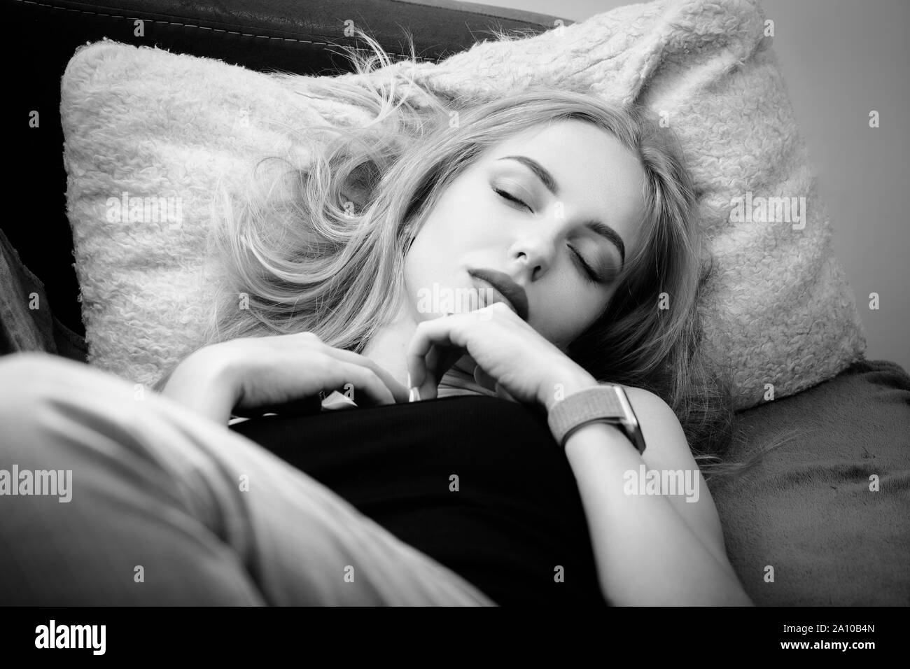 beautiful young woman lying on sofa sleeping top view, monochrome Stock
