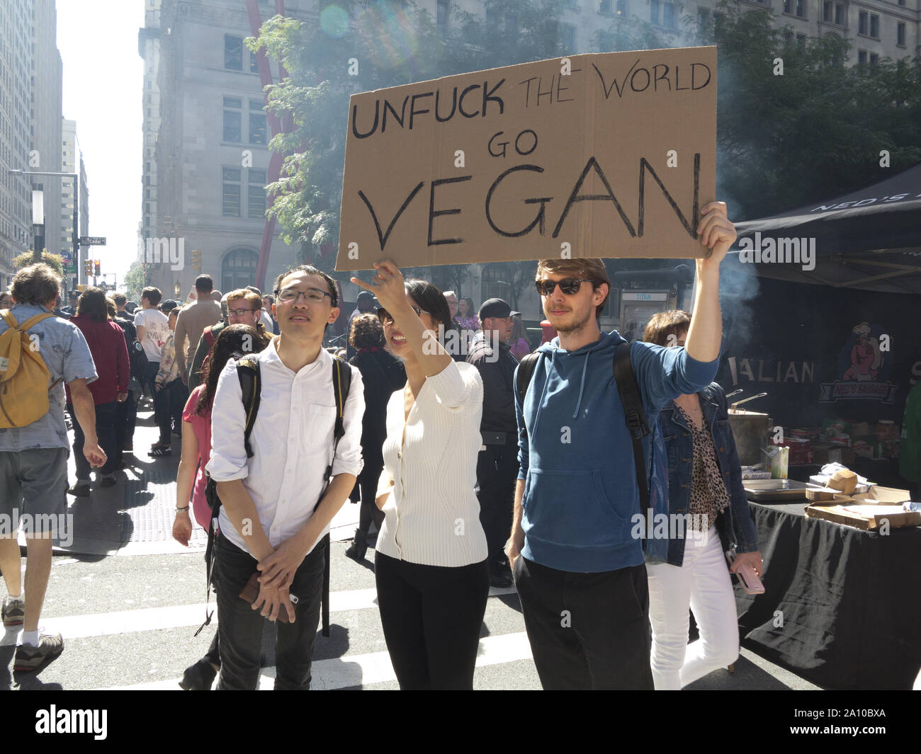 New York City, USA. 20th September, 2019, Climate Strike. Young adults hold sign that urges going Vegan to save the world. Stock Photo