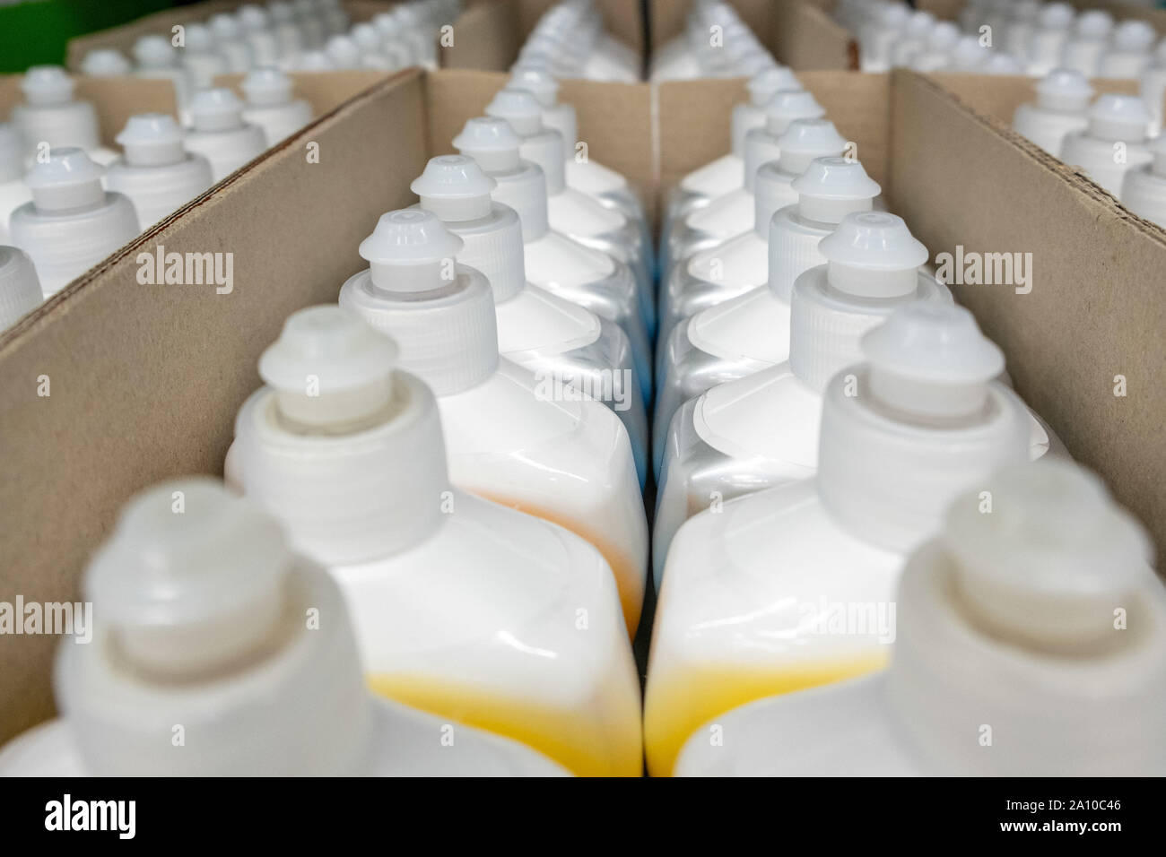 Rows of white plastic dishwasher liquid bottles in diminishing