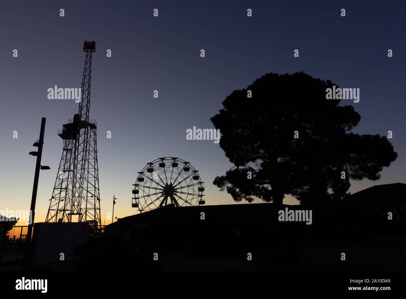 The Ferris whell at Tibidabo amusement park in silhouette at sunrise Stock Photo