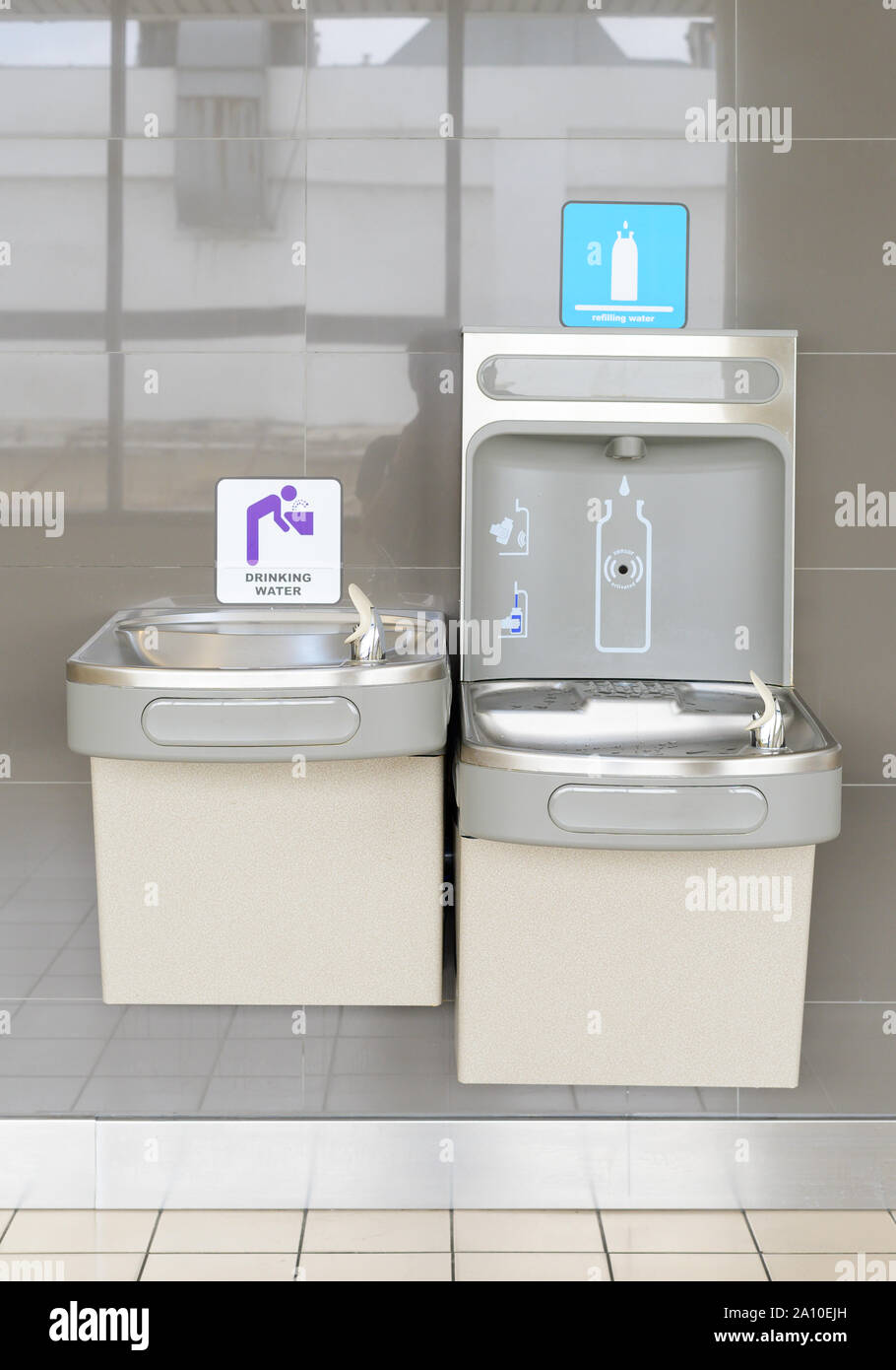 Free drinking water fountain installed on wall in airport Stock Photo