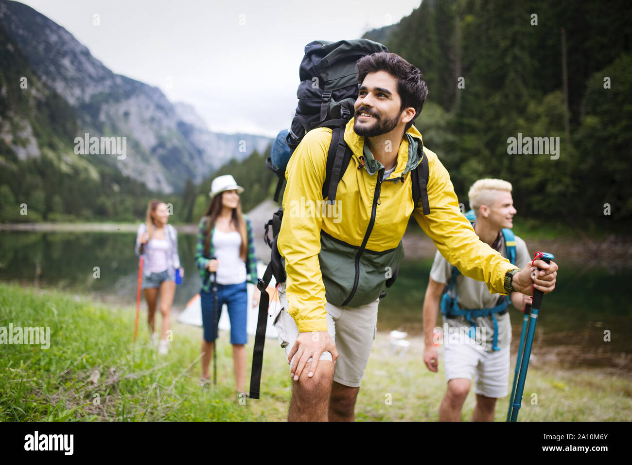 Group of young friends hiking in countryside. Multiracial happy people ...