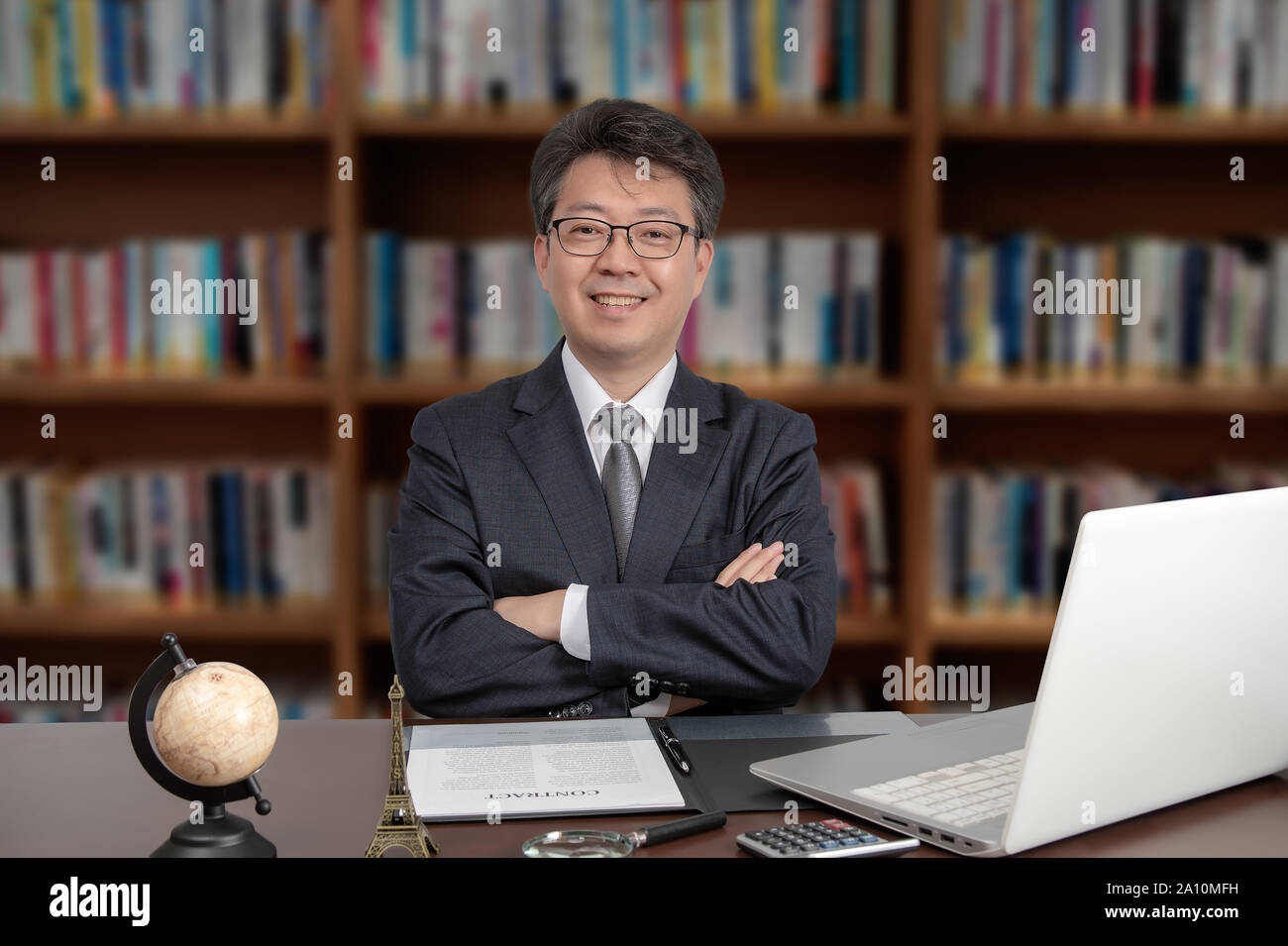A portrait of an Asian middle-aged male businessman sitting at a desk Stock Photo