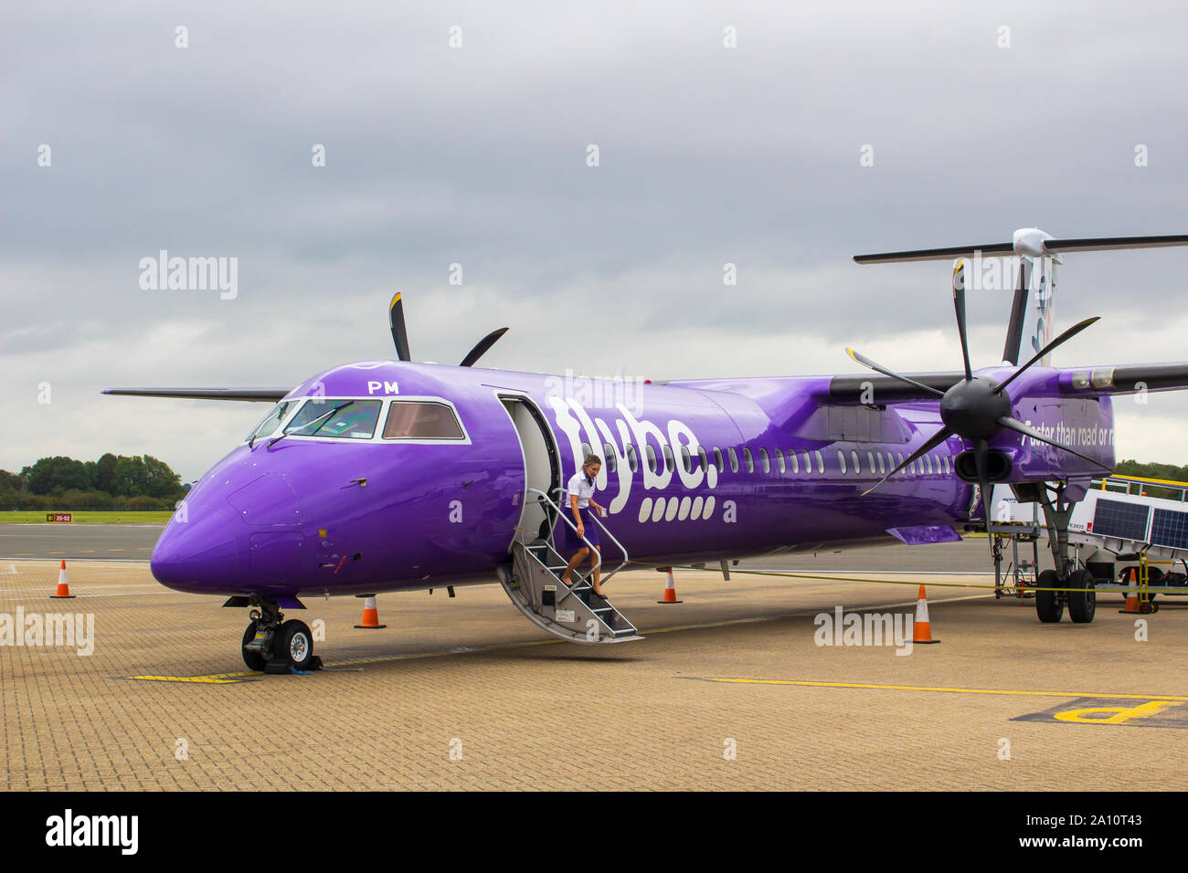 16 September 2019 A FlyBe Dash 8 Commercial Airliner with luggage and passenger handlers on the apron at Southampton City Airport in Hampshire England Stock Photo