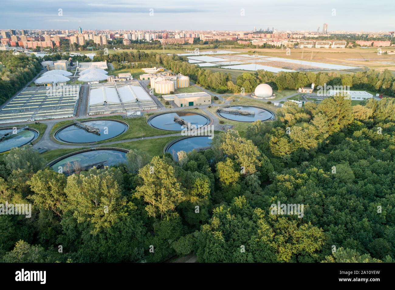 Flying over sewage treatment plant. Aerial view of industrial water  treatment for the city in background. Waste water purification Stock Photo  - Alamy