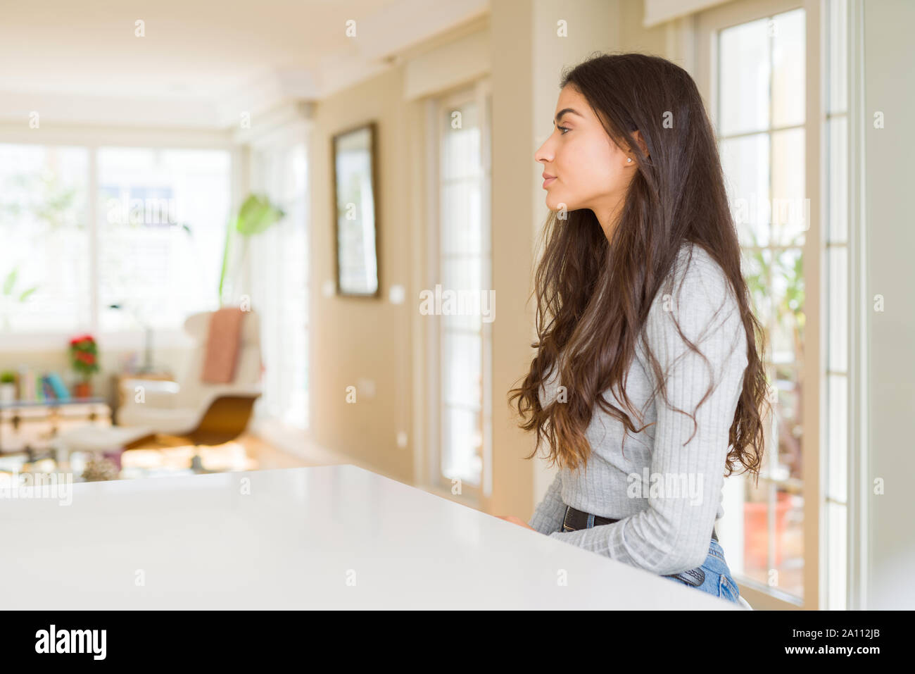Young Beautiful Woman At Home Looking To Side Relax Profile Pose