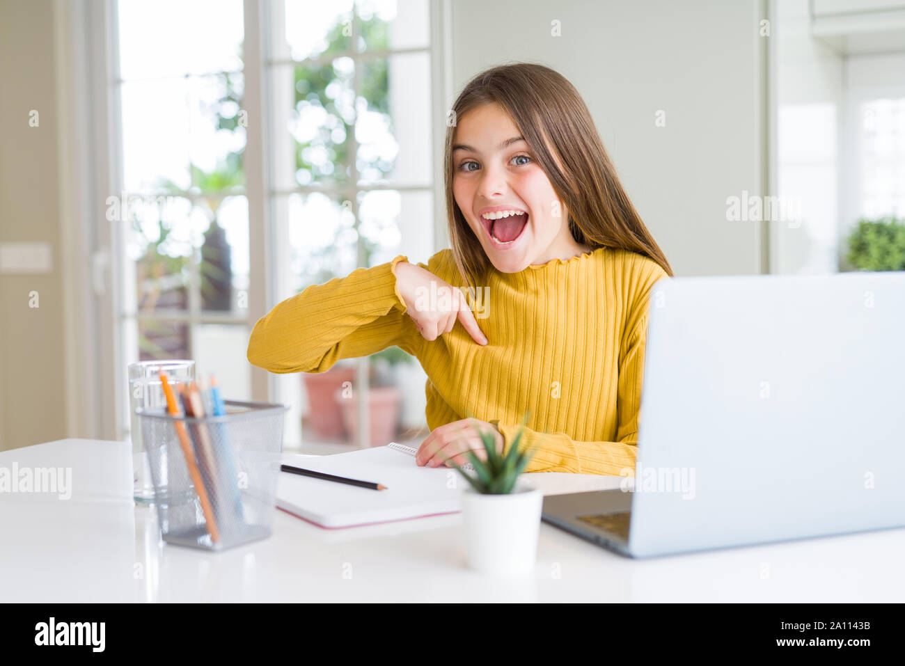Beautiful young girl studying for school using computer laptop with ...