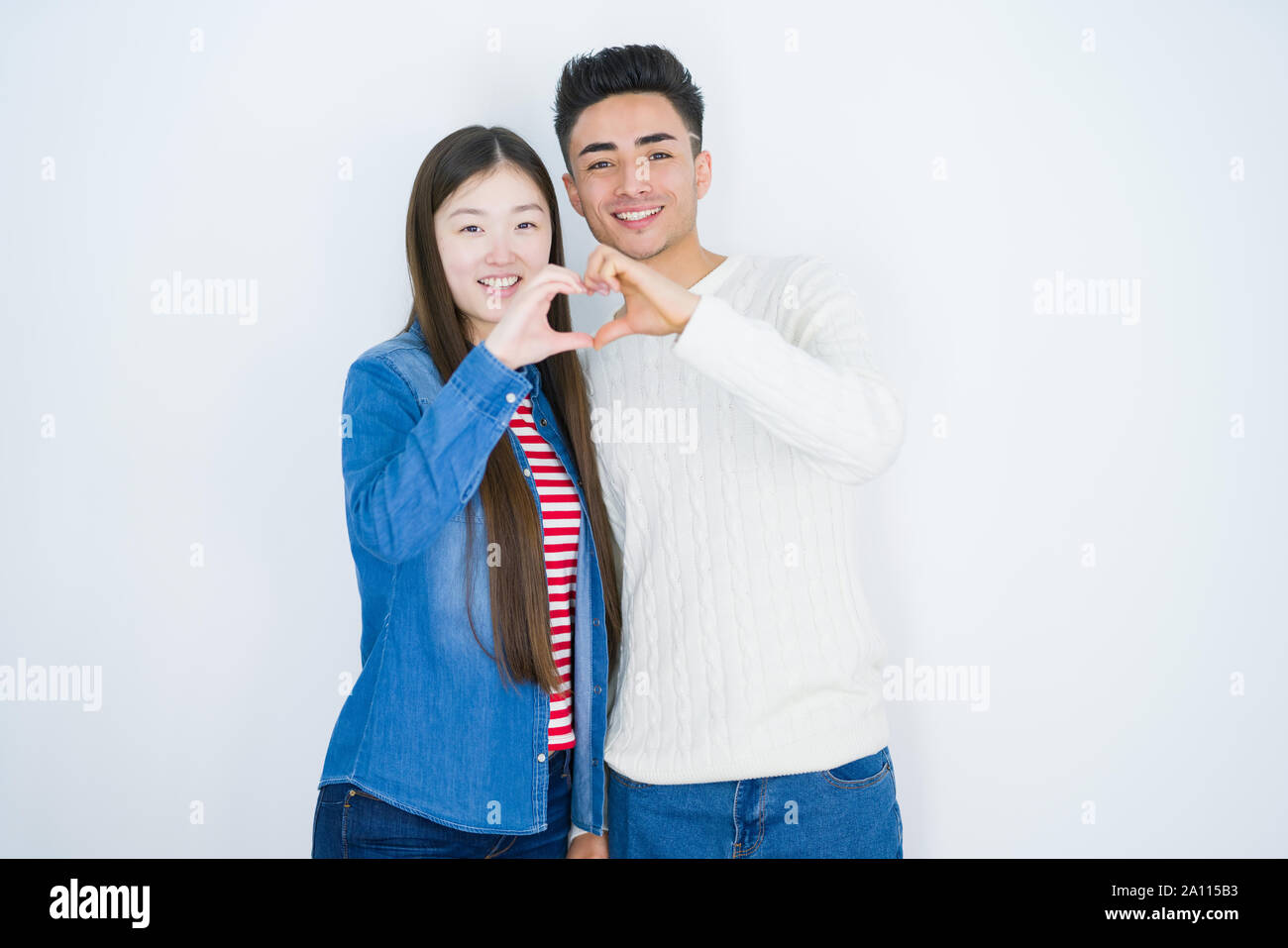 Beautiful young asian couple over white isolated background smiling in ...