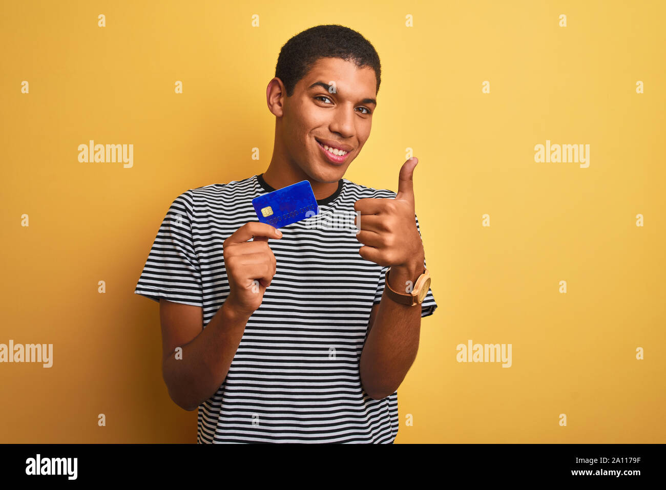 Young handsome arab man holding credit card standing over isolated Young handsome arab man holding credit card standing over isolated