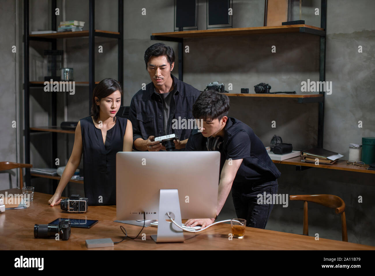Photographers working in studio Stock Photo - Alamy