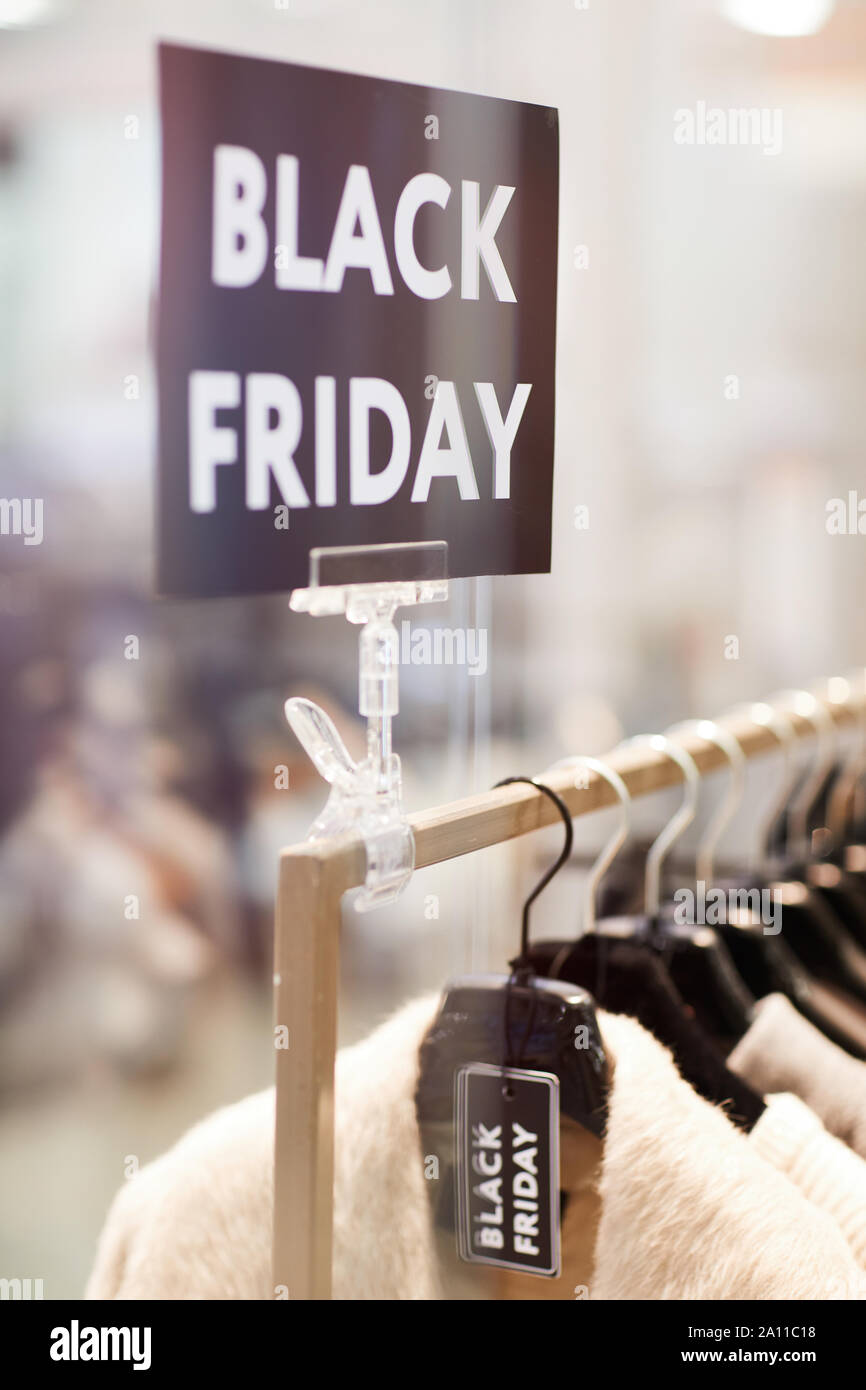 Background image of Black Friday sigh over rack with clothes on sale in