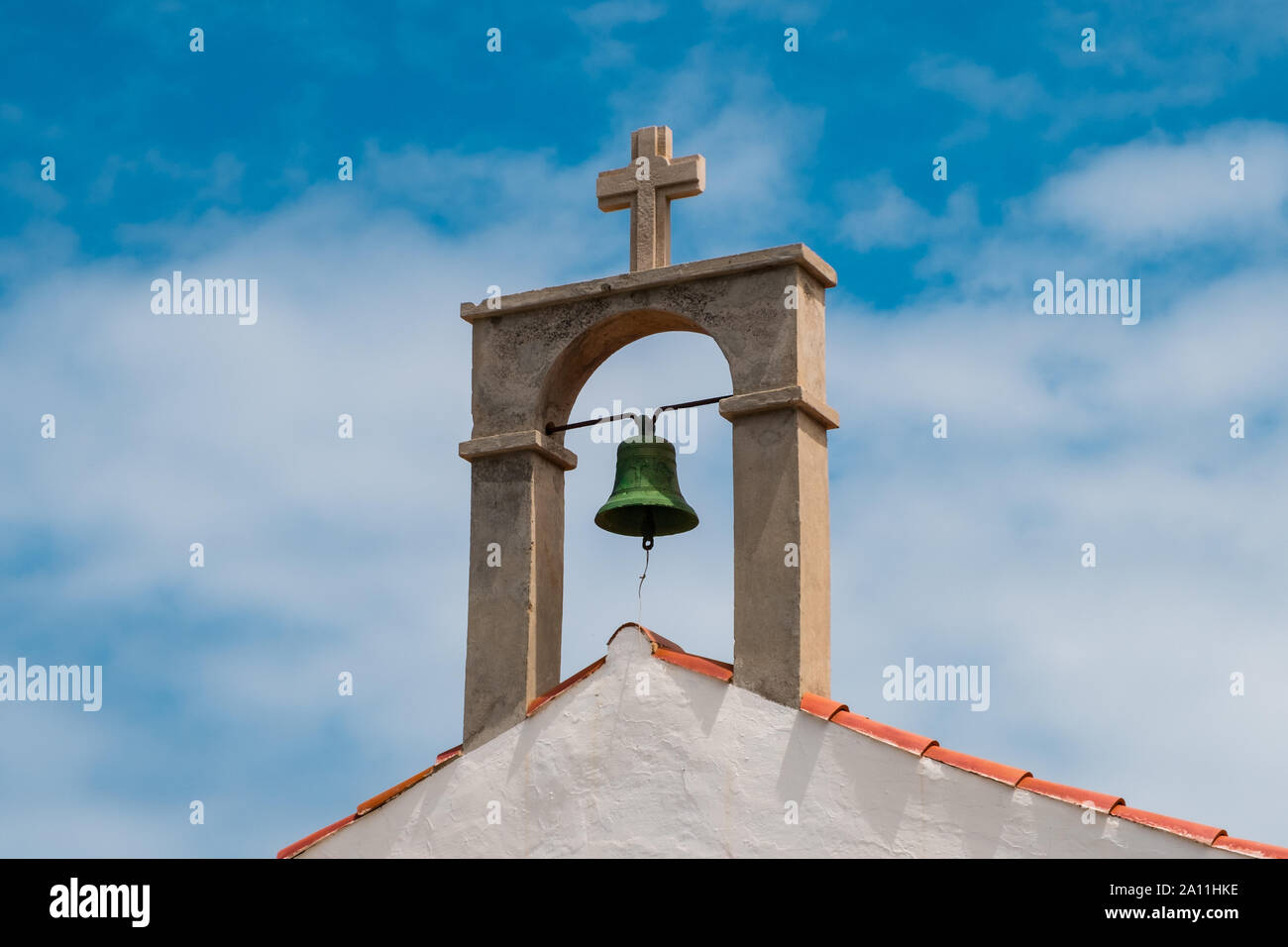 church bell and cross on rural church roof Stock Photo