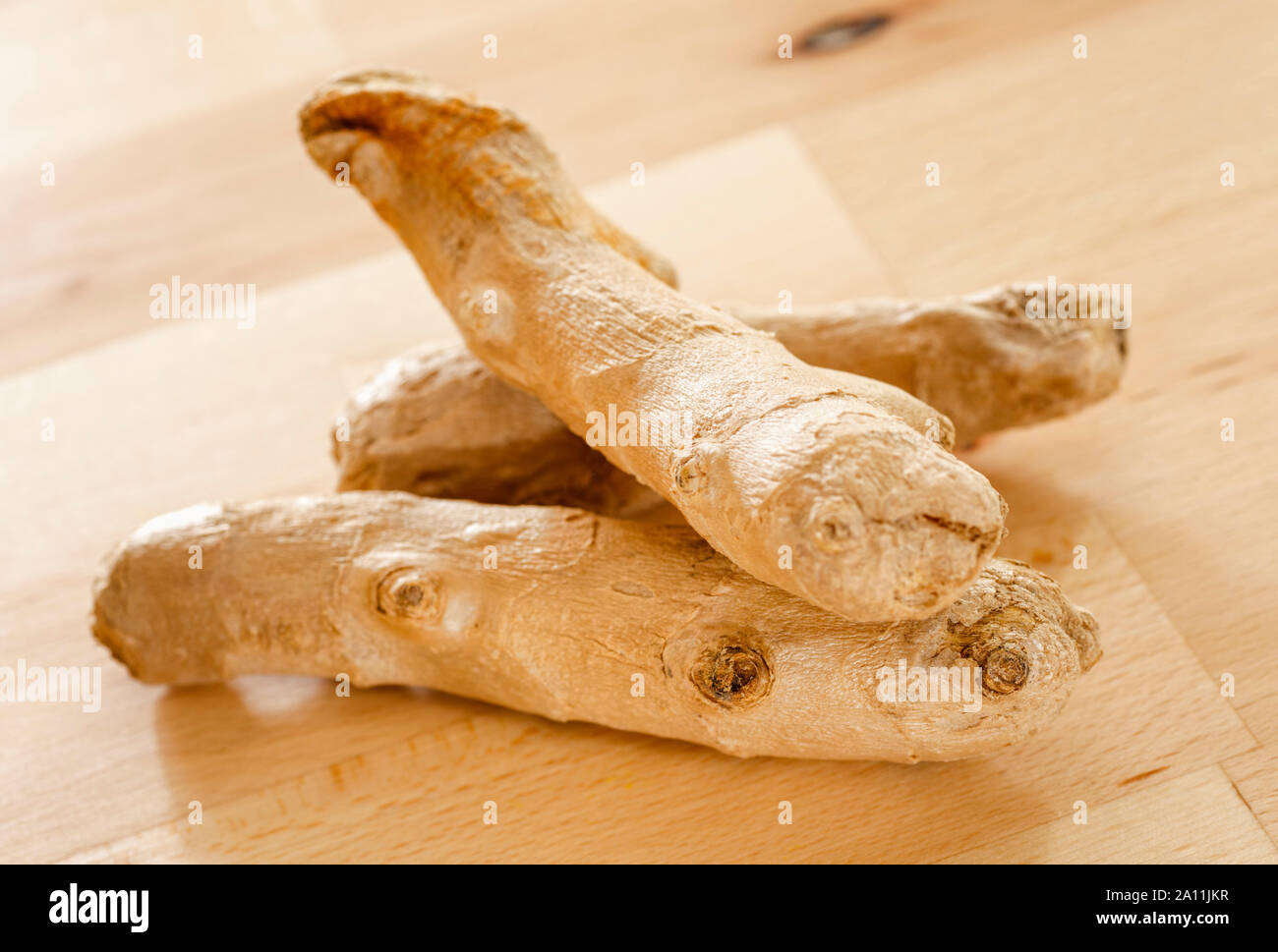 Root ginger on a wooden surface Stock Photo