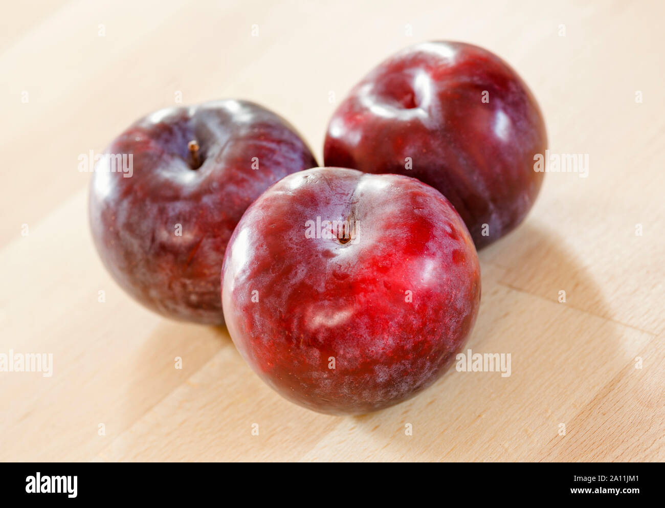 Plums on a wooden surface Stock Photo
