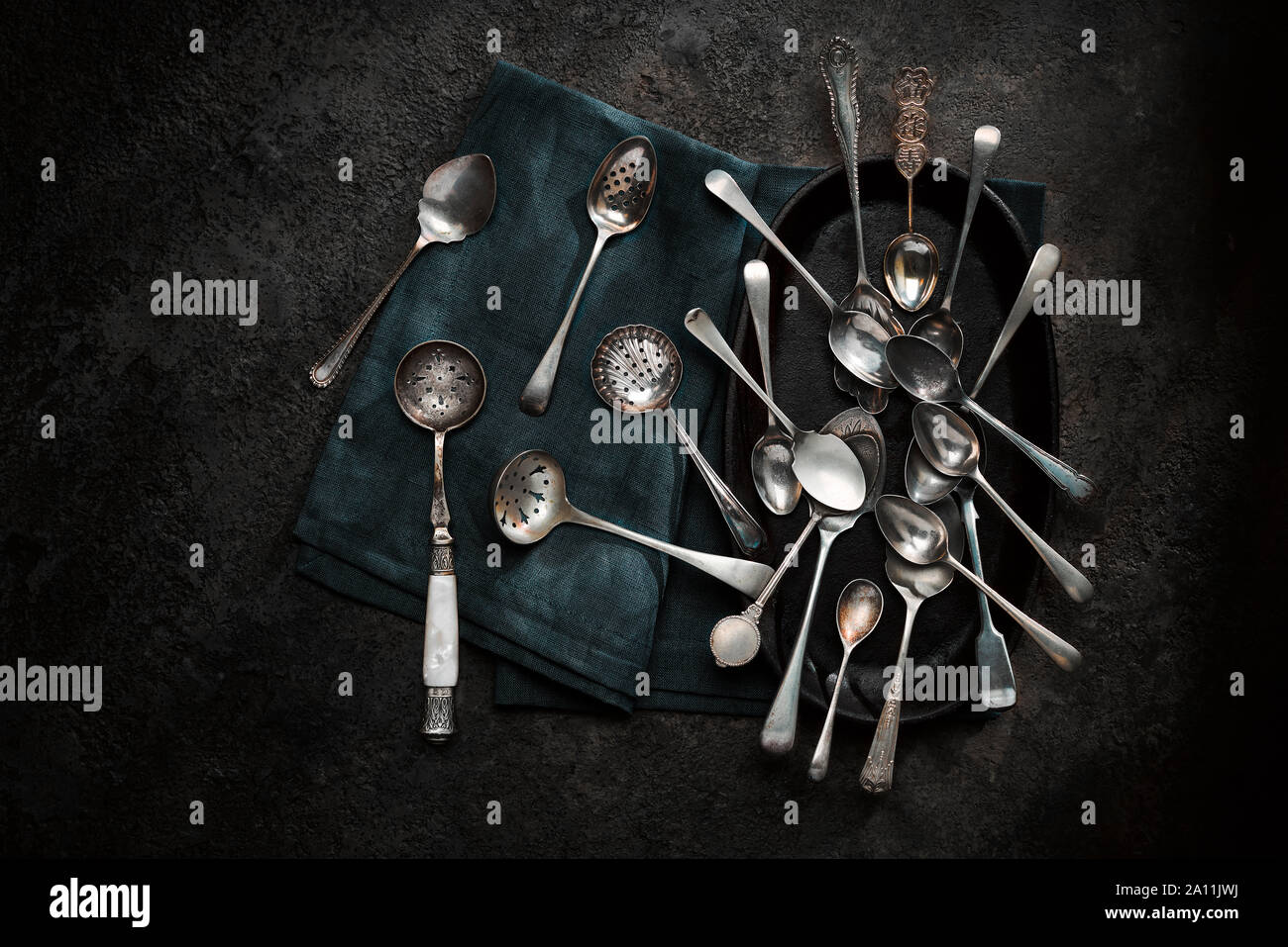 Vintage spoons shot from above on dark background. Stock Photo