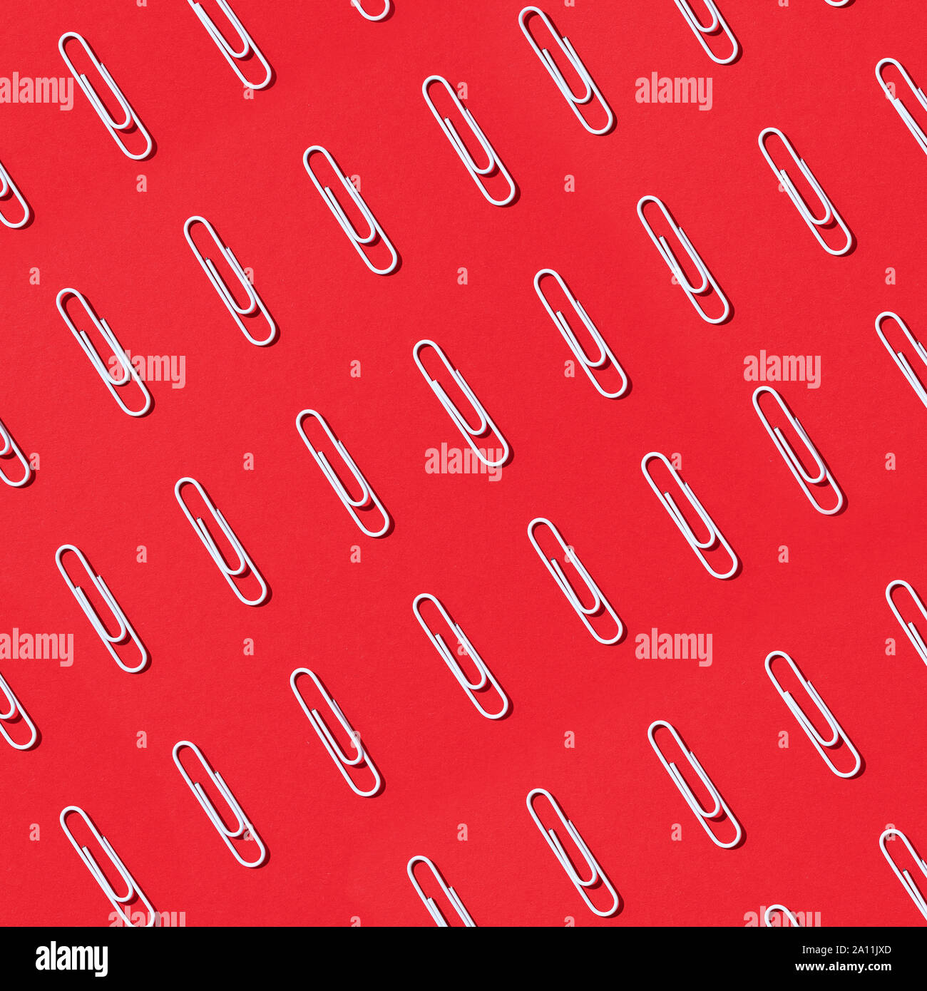 Pattern of white paper clips on red background. Back to school. Office ...