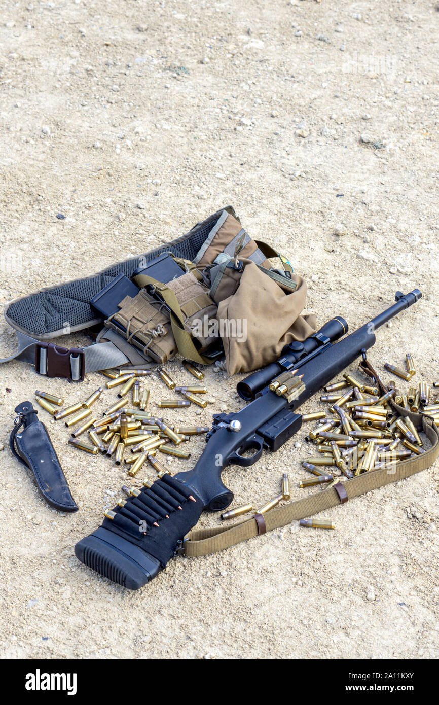 Bolt rifle, ammunition and cartridges on the ground. Concept for