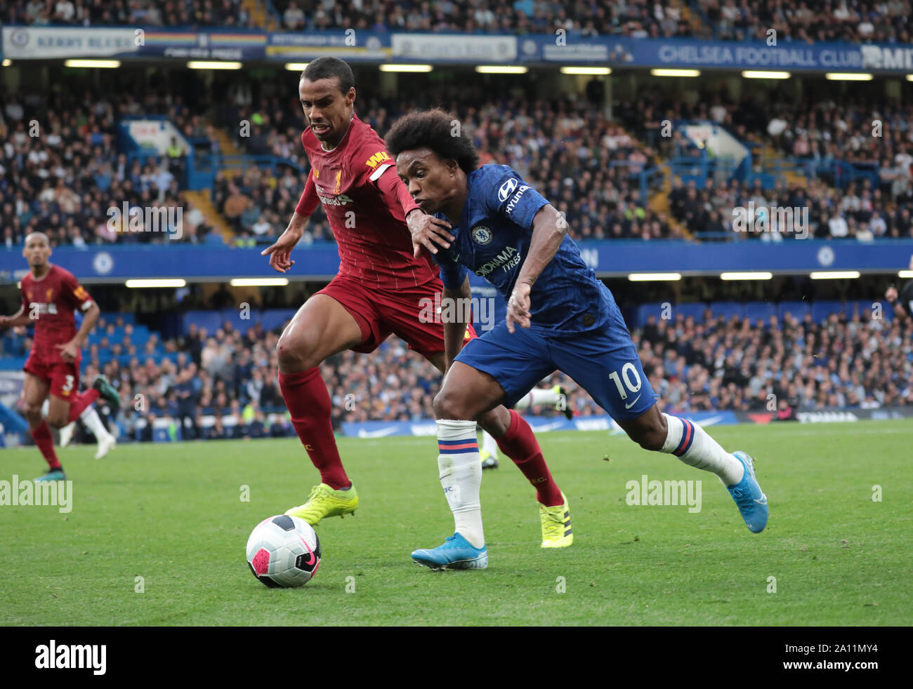 LONDON, ENGLAND - SEPTEMBER 22: Liverpool’s Joel Matip tackles Chelsea’s Willian during the Premier League match between Chelsea FC and Liverpool FC at Stamford Bridge on September 22, 2019 in London, United Kingdom. (Hugo Philpott/MB Media) Stock Photo